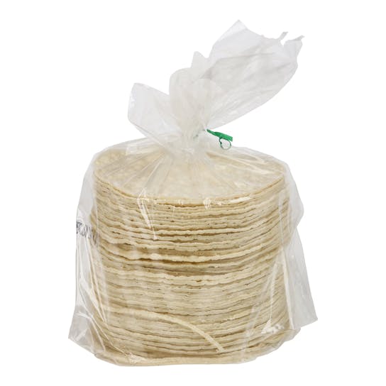 A stack of round corn tortillas in a clear plastic bag, secured at the top with a green twist tie, isolated on a white background.