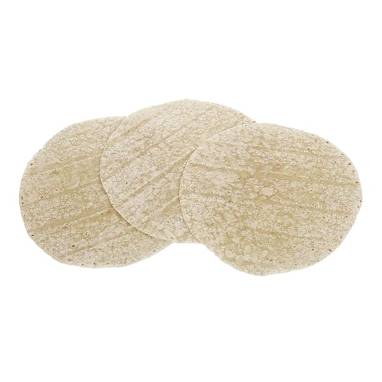 Three plain, round corn tortillas overlapping each other on a white background.